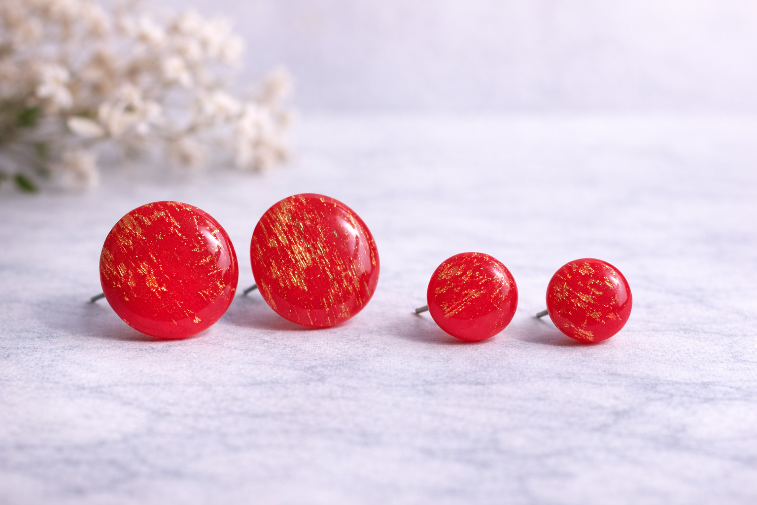 Rote runde Ohrstecker aus Polymer Clay mit goldenen Akzenten, handgefertigt, getragen am Ohr